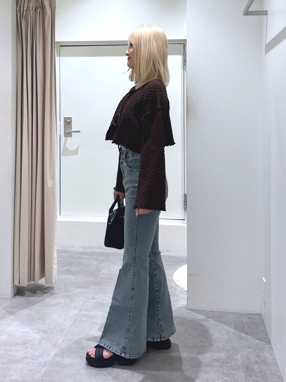 ブラウン系のカーディガン/ボレロ、ブルー系のデニムパンツ、グレー系のキャミソールを着用したレディースの春コーディネートの3枚目の写真