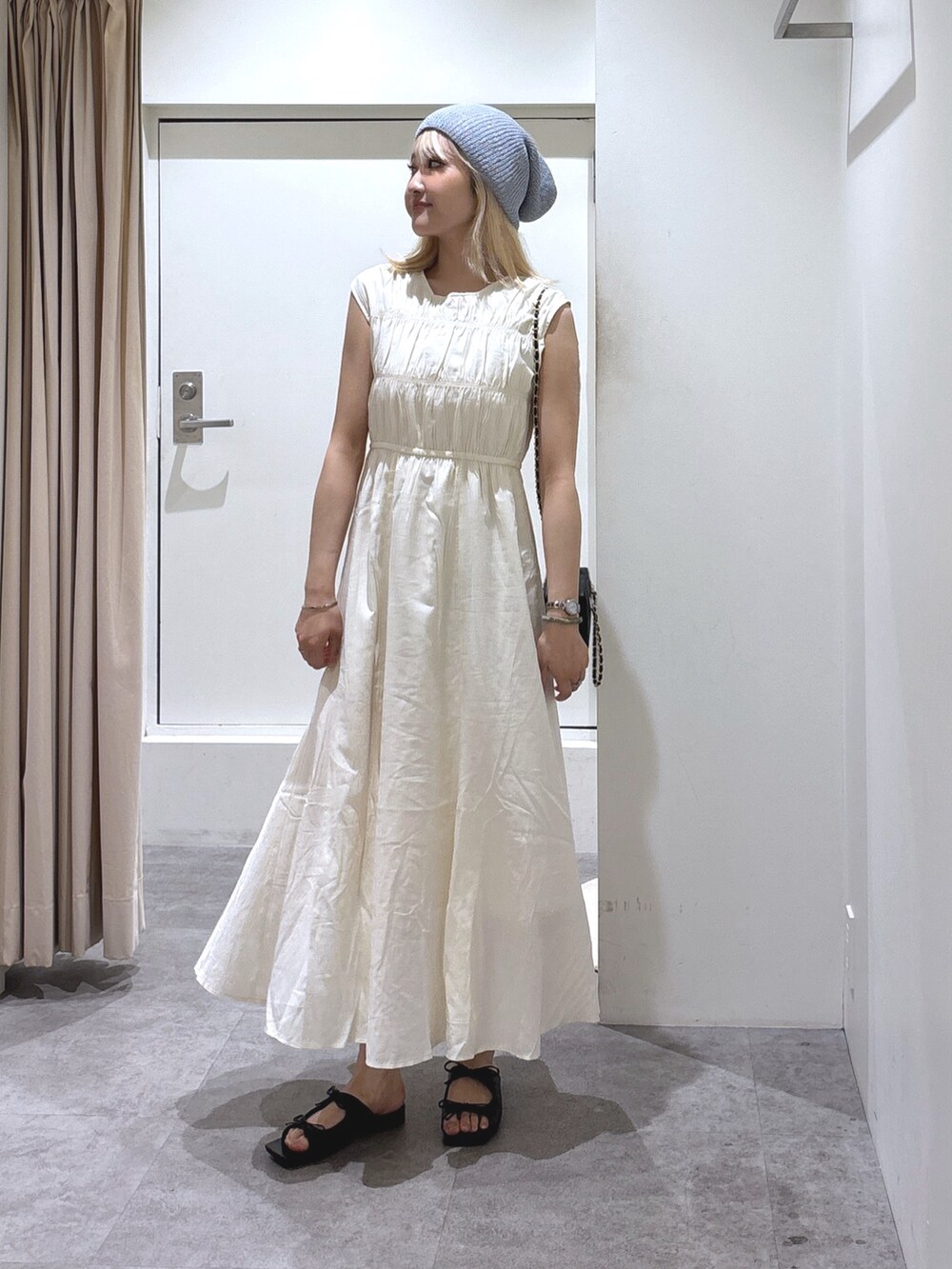 ホワイト系のワンピース、ブラック系のショルダーバッグを着用したレディースの夏コーディネートの2枚目の写真