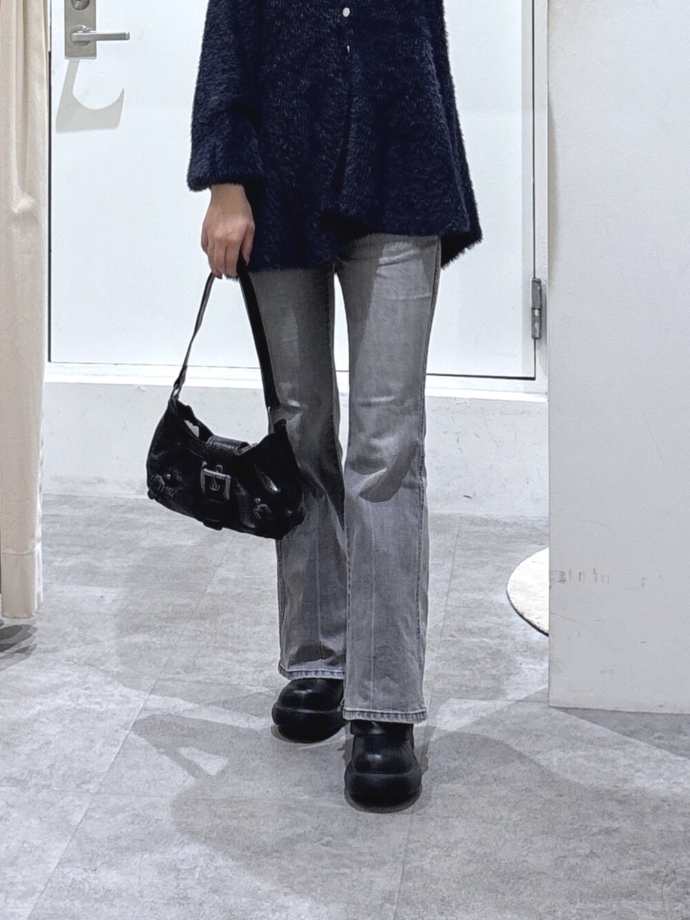 ブルー系のニット/セーター、ブラック系のデニムパンツを着用したレディースの秋コーディネートの3枚目の写真