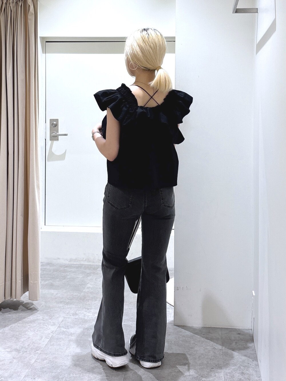 ブラック系のシャツ/ブラウス、ブラック系のデニムパンツを着用したレディースの春コーディネートの3枚目の写真