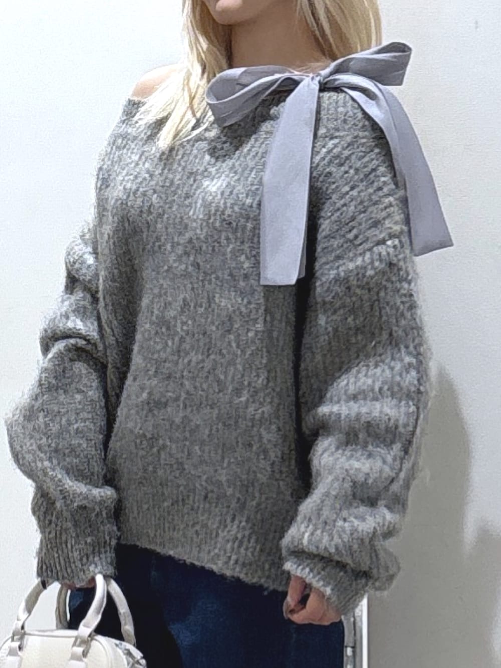 グレー系のニット/セーター、ブルー系のデニムパンツを着用したレディースの冬コーディネートの3枚目の写真