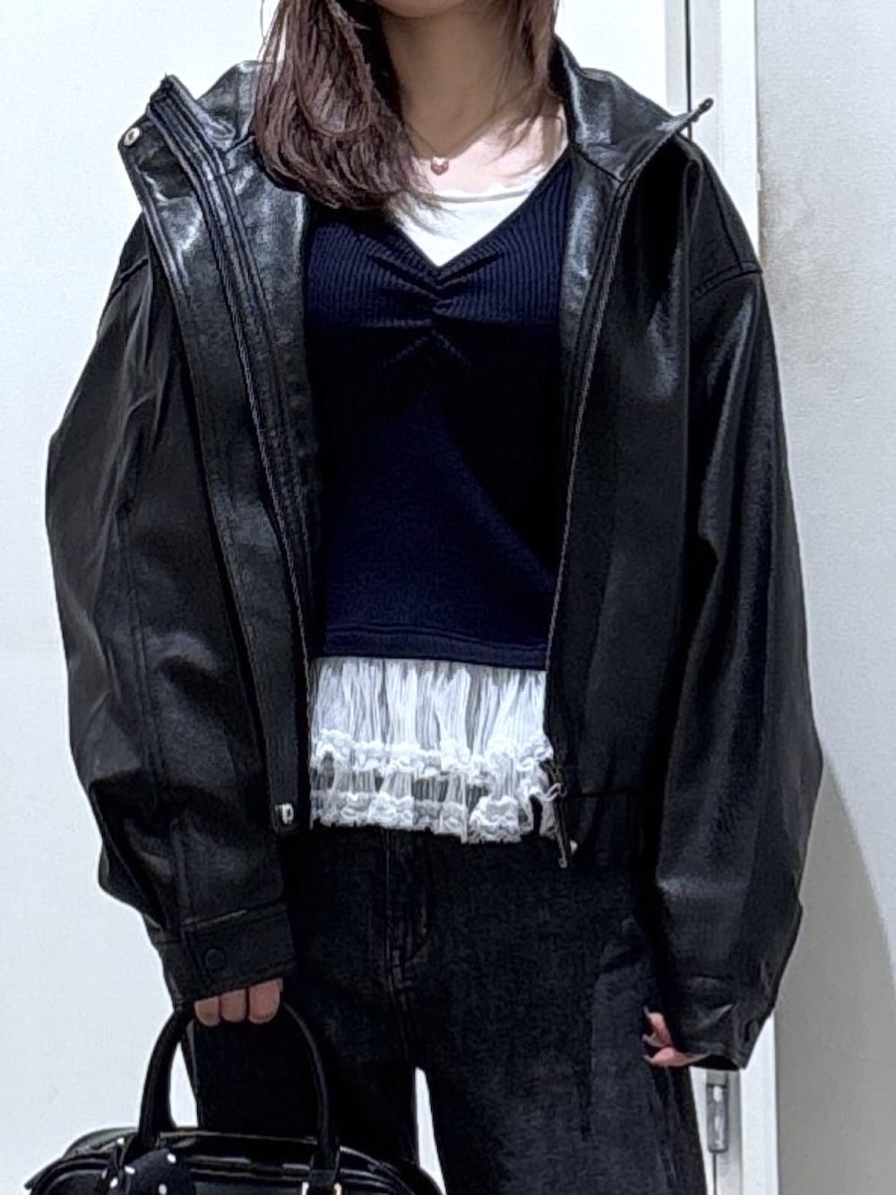 ブルー系のニット/セーター、ブラック系のブルゾン、ブラック系のデニムパンツを着用したレディースの冬コーディネートの2枚目の写真