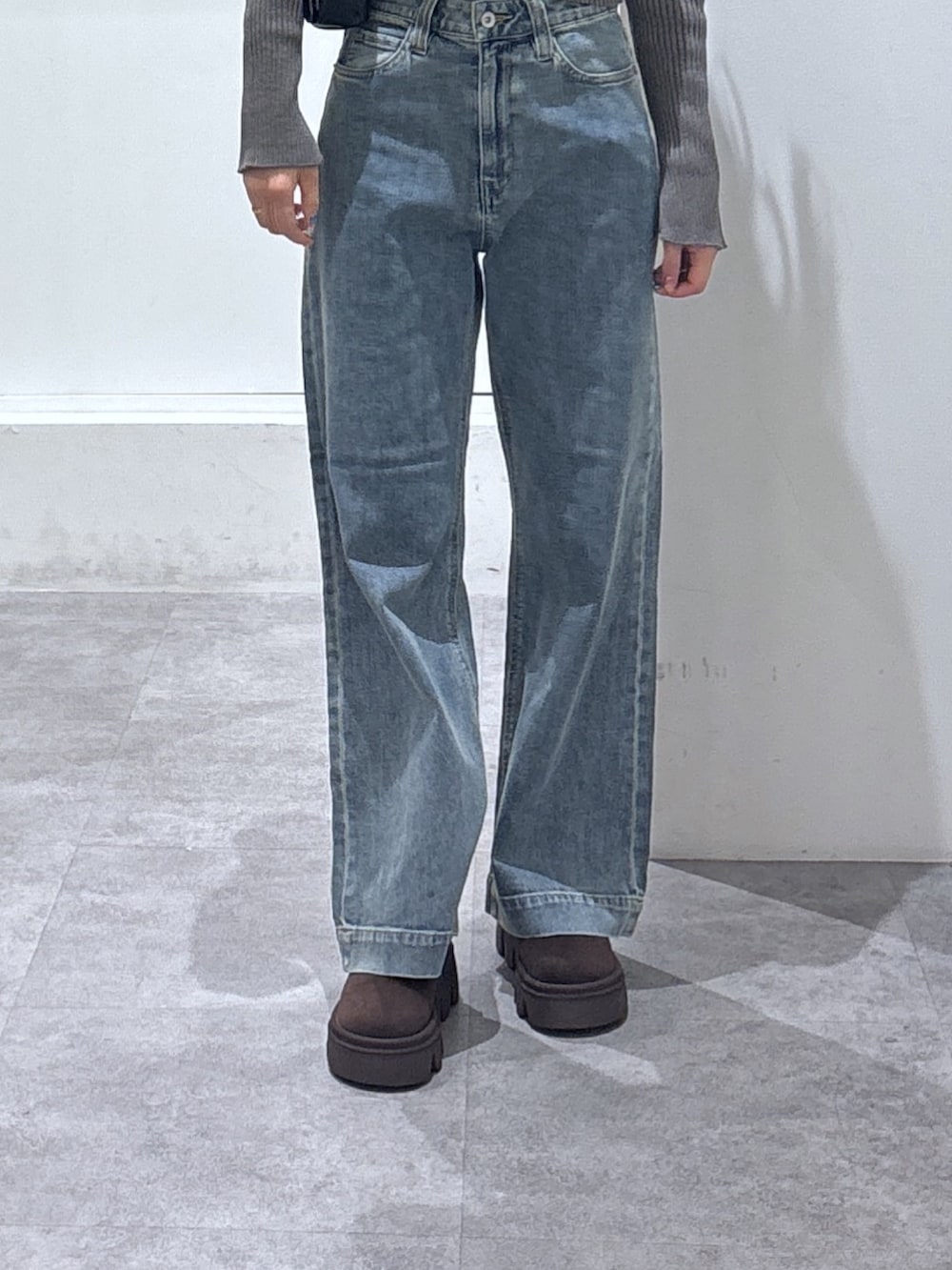 グレー系のパーカー、ブルー系のデニムパンツを着用したレディースの冬コーディネートの2枚目の写真