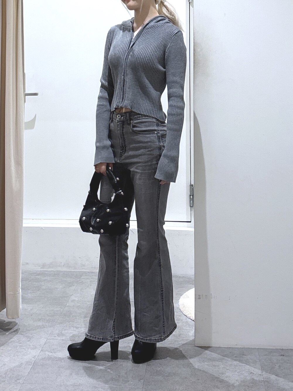 グレー系のパーカー、ブラック系のデニムパンツを着用したレディースの秋コーディネートの3枚目の写真