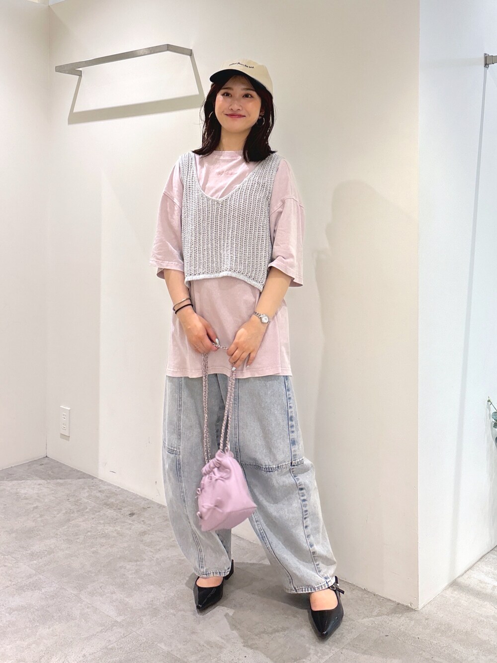 シルバー系のベスト、ピンク系のTシャツ/カットソー、ブルー系のデニムパンツを着用したレディースの夏コーディネートの2枚目の写真