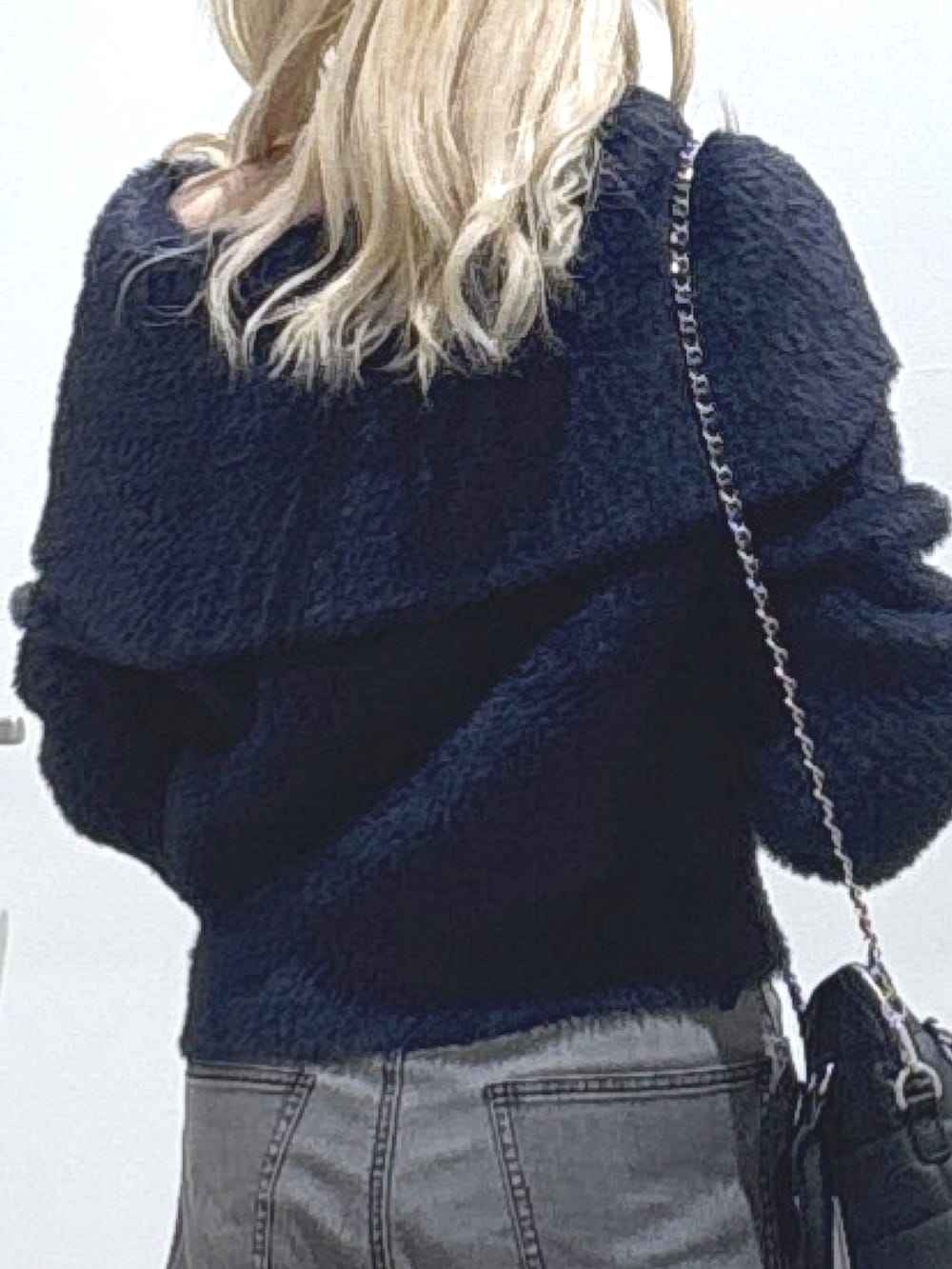 ブルー系のニット/セーター、ブラック系のデニムパンツ、ブラック系のトートバッグを着用したレディースの冬コーディネートの3枚目の写真