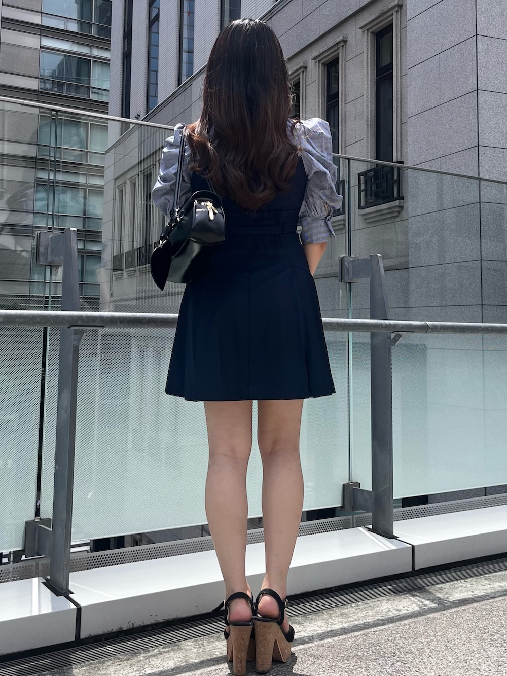 ブルー系のワンピース、ブラック系のハンドバッグ、ブラック系のサンダルを着用したレディースの夏コーディネートの3枚目の写真