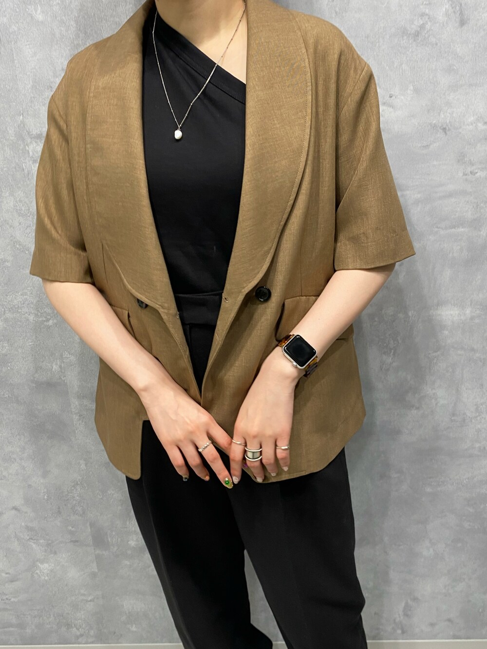 ブラック系のスラックス、ブラック系のTシャツ/カットソーを着用したレディースの春コーディネートの2枚目の写真