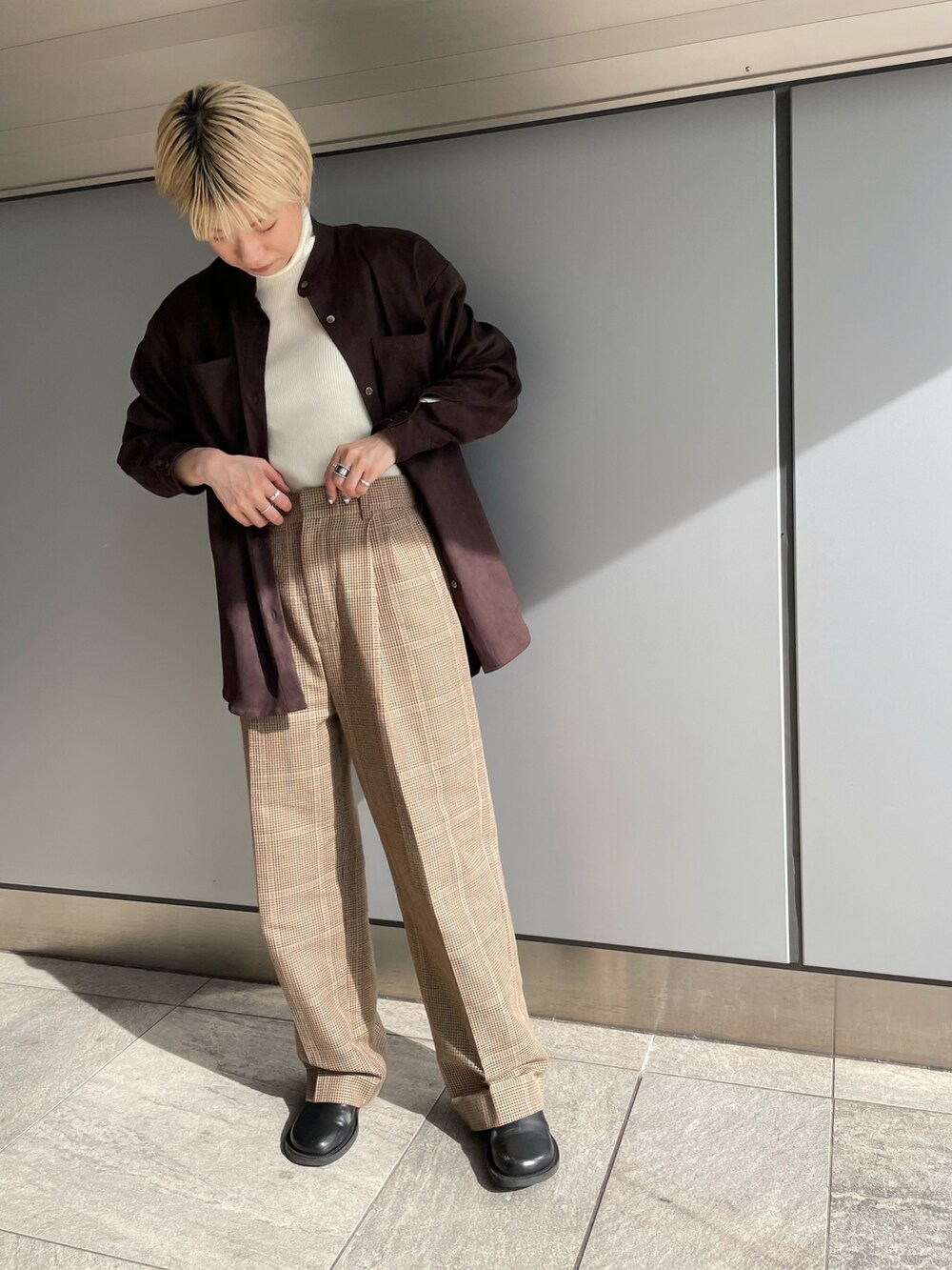 ブラウン系のシャツ/ブラウス、ベージュ系のスラックス、ホワイト系のニット/セーターを着用したレディースの春コーディネートの2枚目の写真