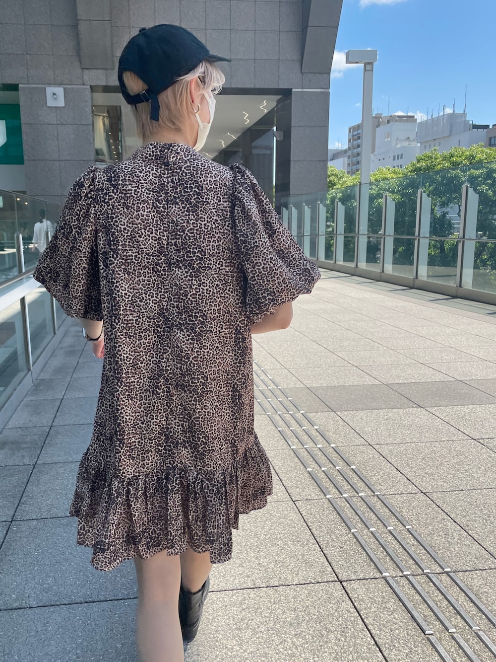 ブラック系のテーラードジャケット、ブラウン系のワンピース、ブラック系のキャップを着用したレディースの春コーディネートの2枚目の写真