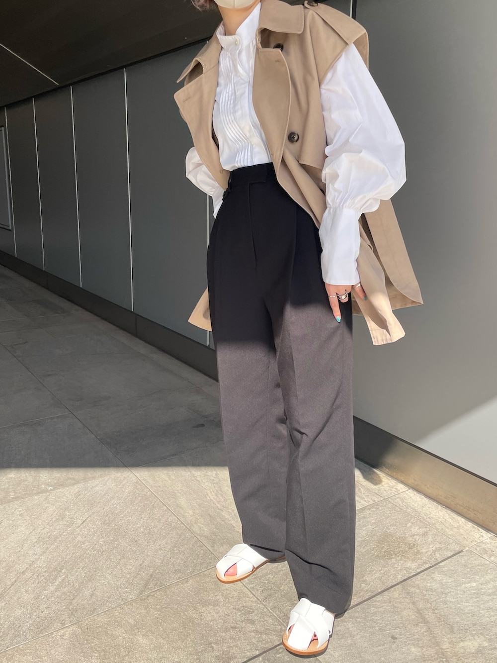 ベージュ系のその他アウター、ホワイト系のシャツ/ブラウス、ブラック系のスラックスを着用したレディースの春コーディネートの2枚目の写真