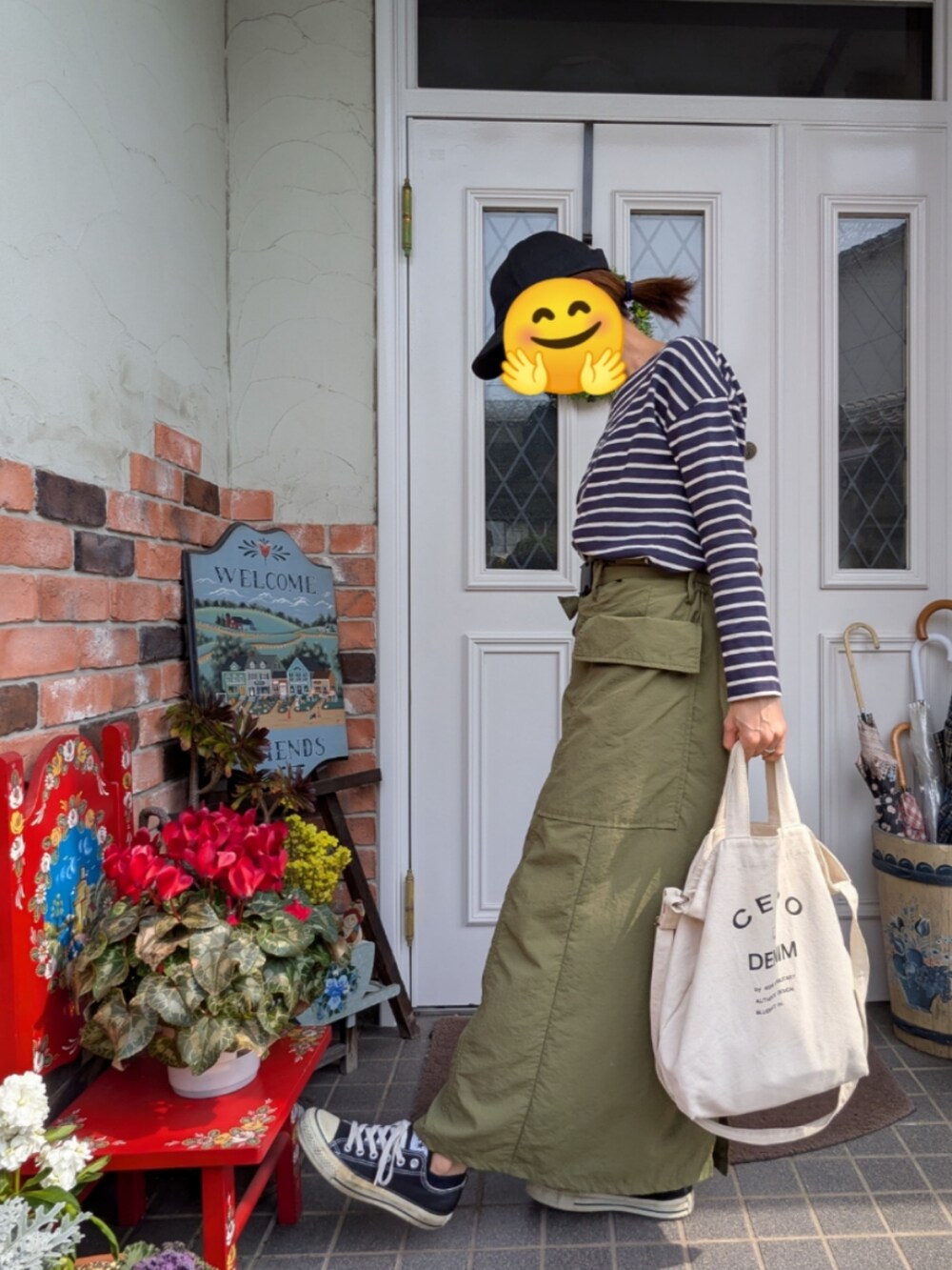 グリーン系のスカート、ブルー系のTシャツ/カットソー、ホワイト系のトートバッグを着用したレディースの春コーディネートの3枚目の写真