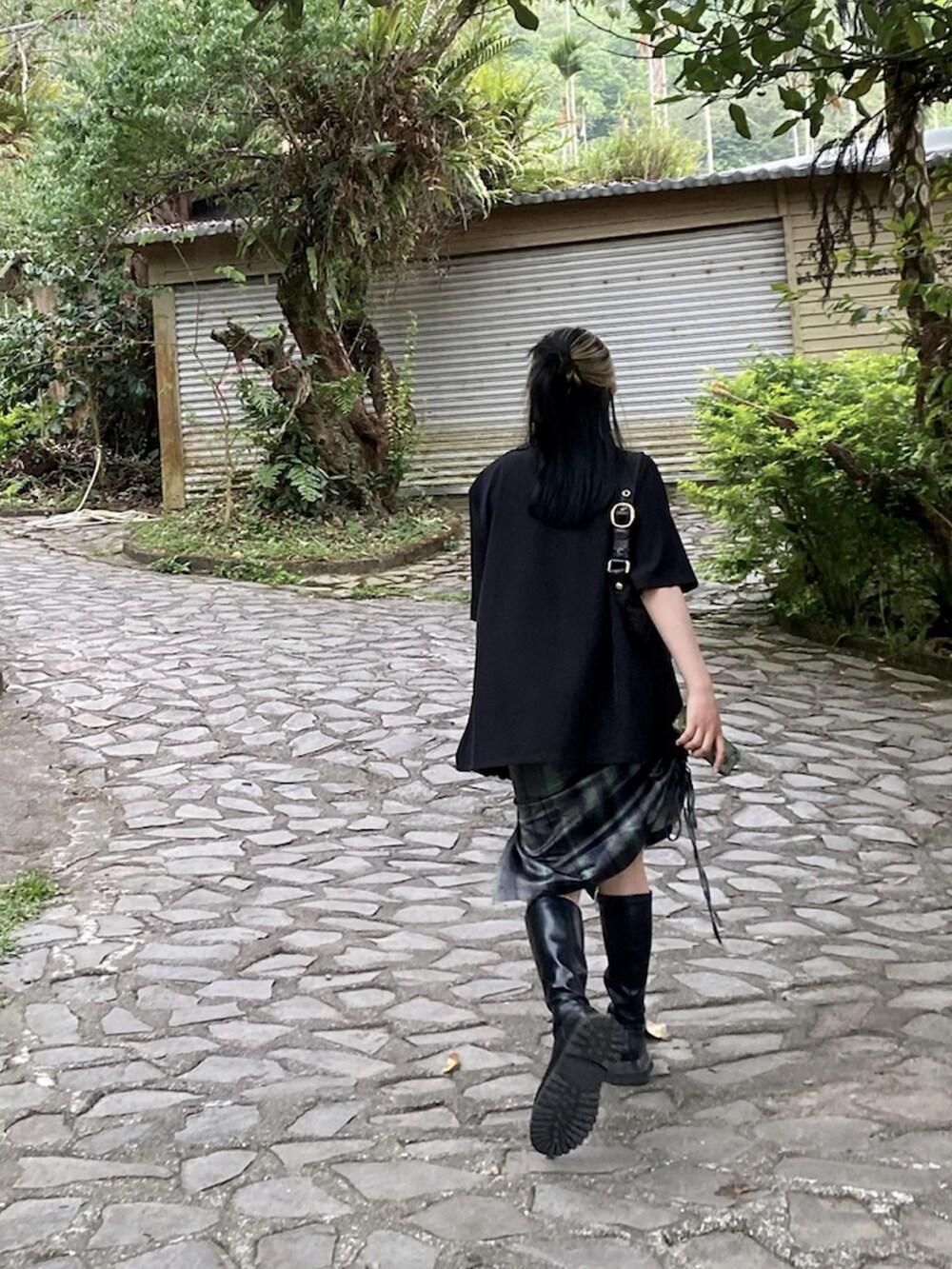 ブラック系のテーラードジャケット、グリーン系のワンピースを着用したレディースの春コーディネートの2枚目の写真