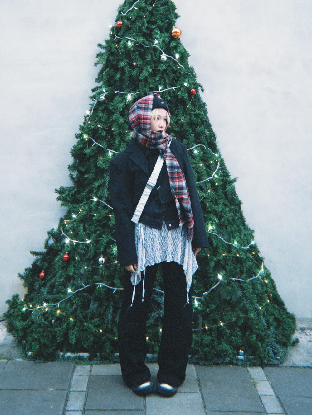 ブラック系のスカート、シルバー系のブーツ、レッド系のマフラーを着用したレディースの冬コーディネートの2枚目の写真