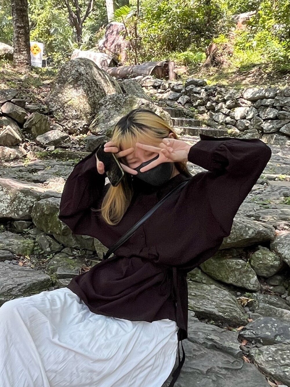 ブラック系のトップスを着用したレディースの春コーディネートの2枚目の写真