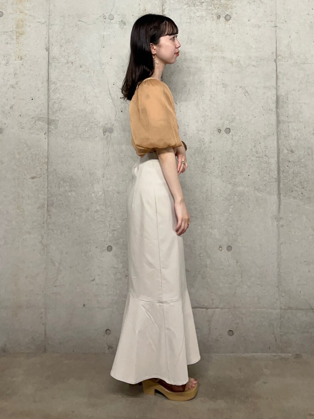 ベージュ系のニット/セーター、ベージュ系のスカート、ベージュ系のサンダルを着用したレディースの夏コーディネートの2枚目の写真