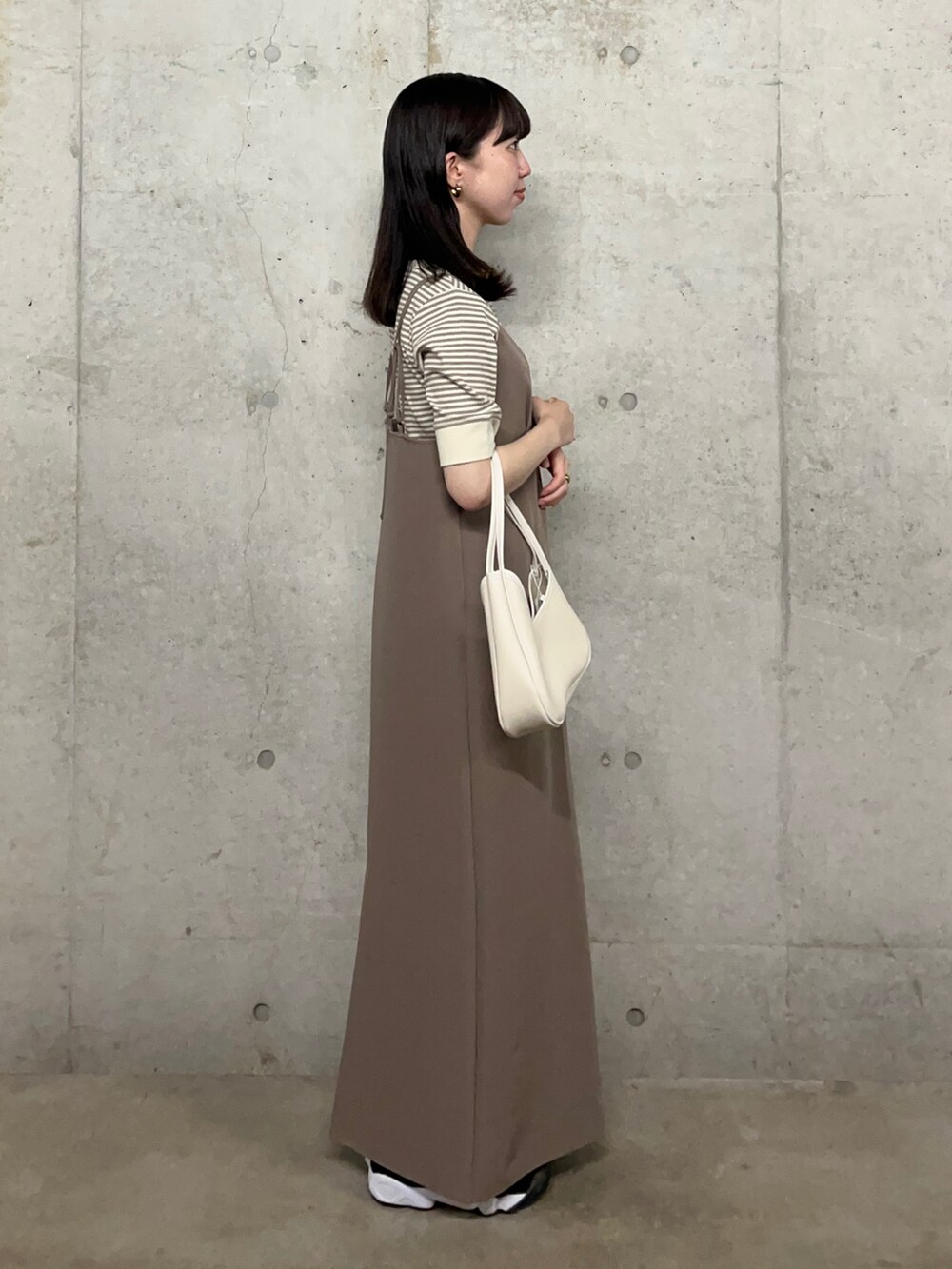 ホワイト系のTシャツ/カットソー、ブラウン系のワンピース、ホワイト系のハンドバッグを着用したレディースの夏コーディネートの2枚目の写真