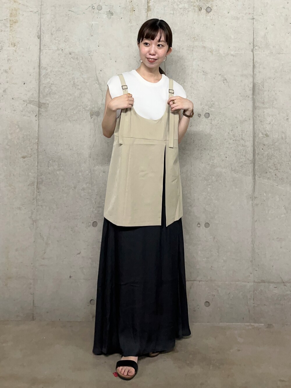 ブラック系のサンダル、ベージュ系のキャミソール、グレー系のスカートを着用したレディースの夏コーディネートの2枚目の写真