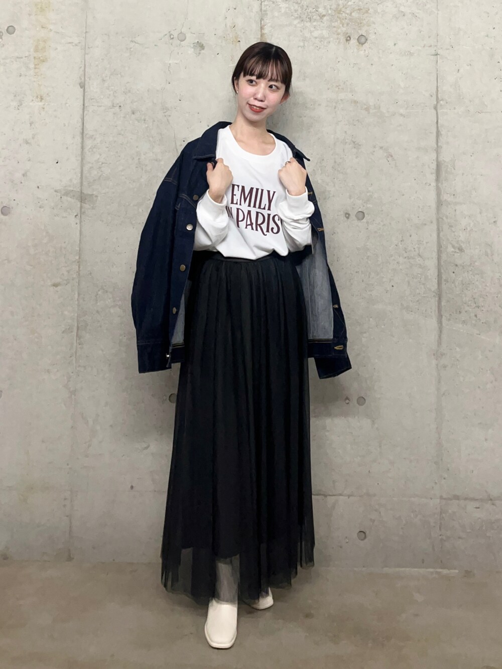ブルー系のデニムジャケット、ブラック系のスカート、その他のTシャツ/カットソーを着用したレディースの秋コーディネートの2枚目の写真