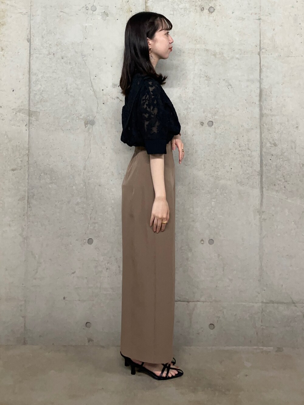 ブラック系のシャツ/ブラウス、ブラウン系のスカート、ホワイト系のサンダルを着用したレディースの夏コーディネートの2枚目の写真