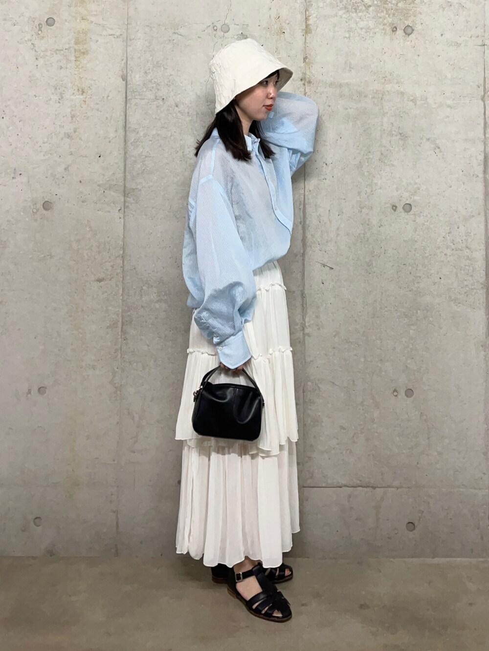 ホワイト系のスカート、グレー系のシャツ/ブラウス、ブラック系のサンダルを着用したレディースの夏コーディネートの2枚目の写真