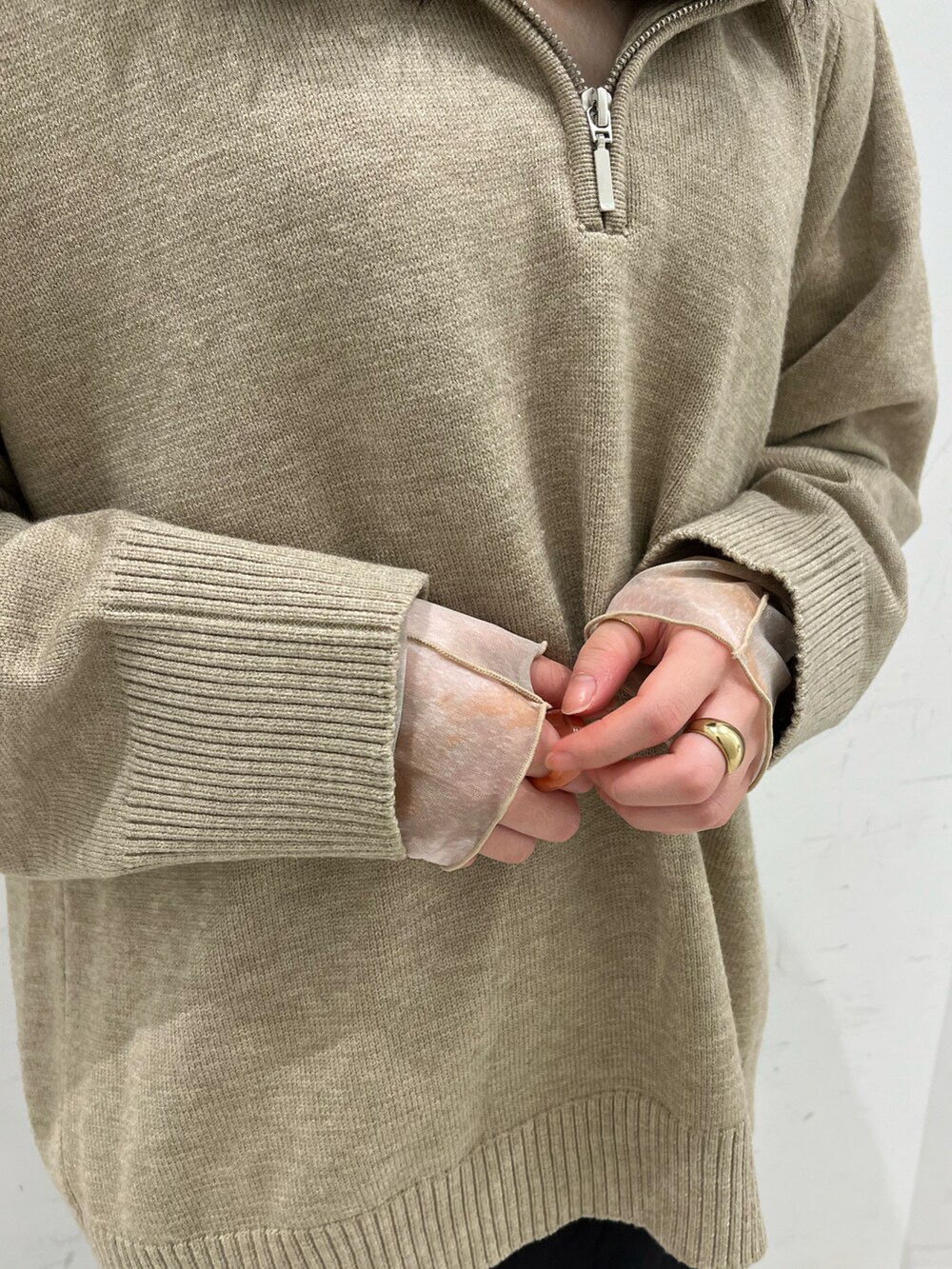 ブラウン系のブーツ、ベージュ系のニット/セーター、ブラック系のスカートを着用したレディースの冬コーディネートの3枚目の写真