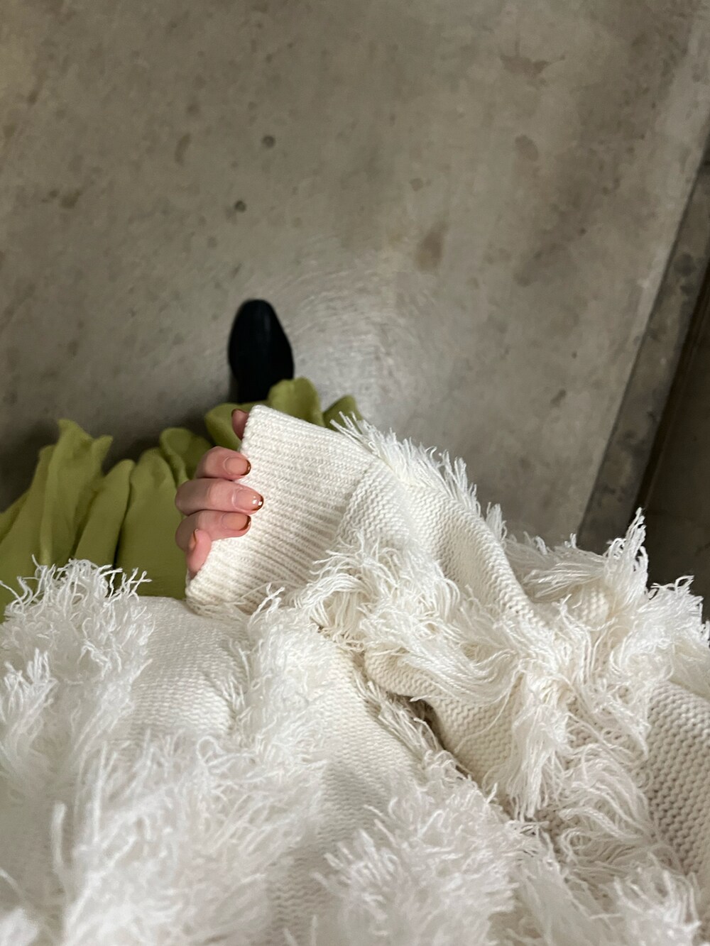 ブラック系のブーツ、イエロー系のスカート、ホワイト系のニット/セーターを着用したレディースの秋コーディネートの2枚目の写真