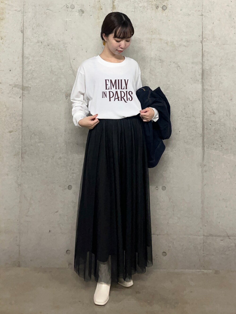 ホワイト系のブーツ、ブラック系のスカート、その他のTシャツ/カットソーを着用したレディースの秋コーディネートの2枚目の写真