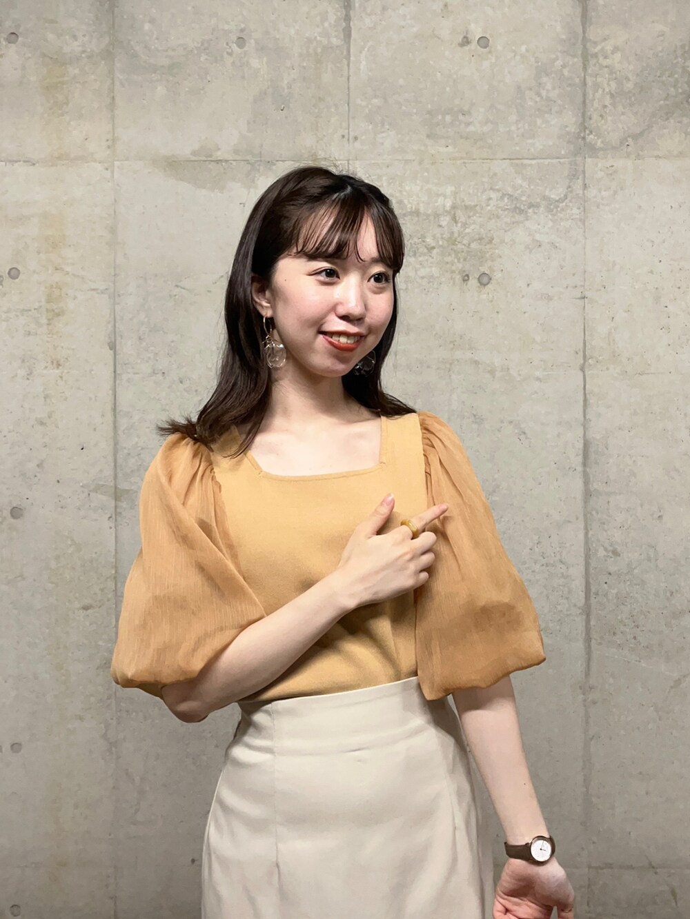 ベージュ系のニット/セーター、ベージュ系のスカート、ベージュ系のサンダルを着用したレディースの夏コーディネートの3枚目の写真