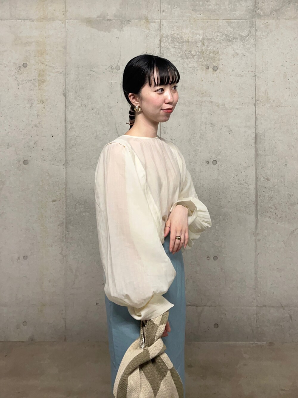 ホワイト系のパンプス、ホワイト系のシャツ/ブラウス、ブルー系のスカートを着用したレディースの春コーディネートの2枚目の写真