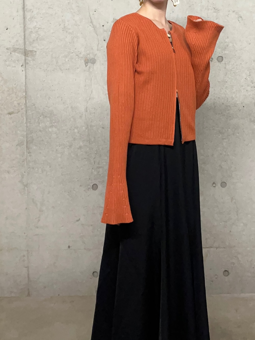 ブラック系のワンピース、オレンジ系のニット/セーター、その他のバレエシューズを着用したレディースの秋コーディネートの3枚目の写真