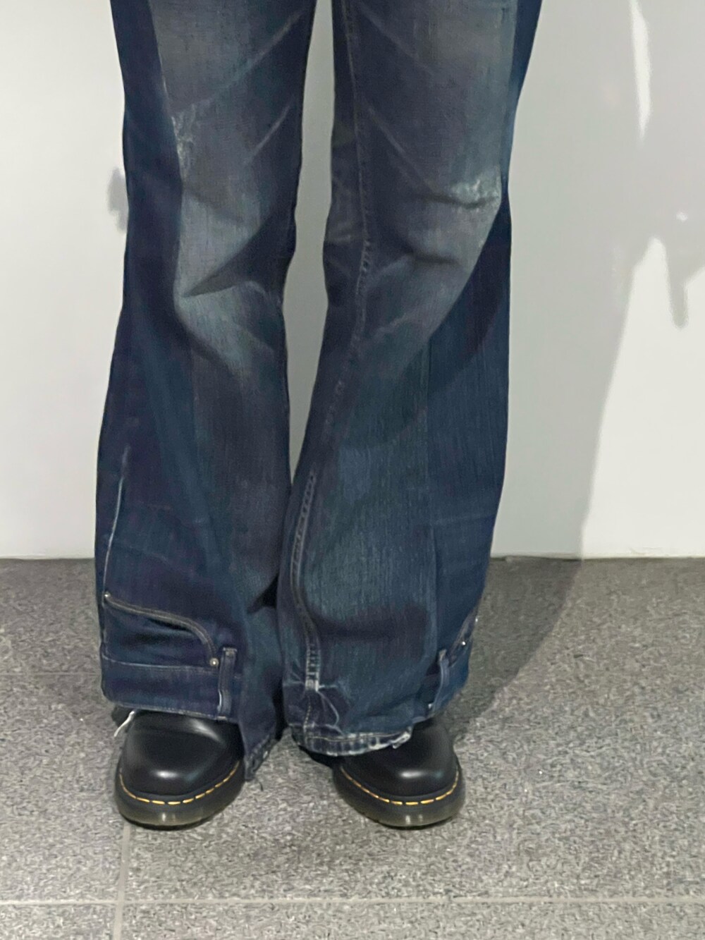 ブルー系のデニムパンツ、ホワイト系のTシャツ/カットソー、ブラック系のバッグを着用したレディースの秋コーディネートの5枚目の写真