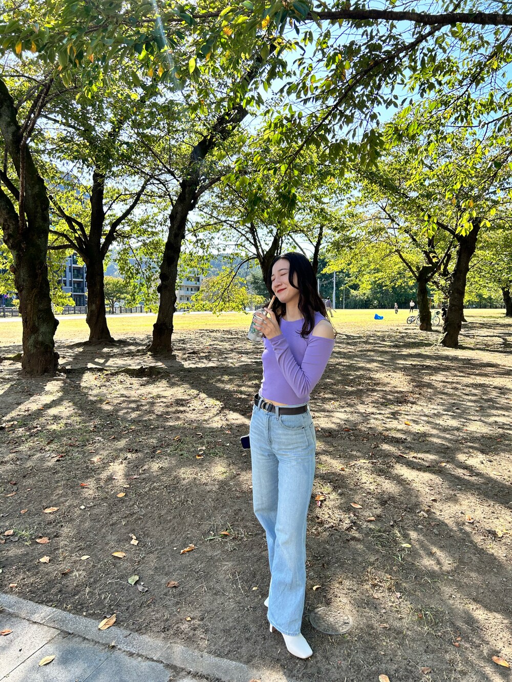 パープル系のTシャツ/カットソー、ブルー系のデニムパンツ、ブラック系のバッグを着用したレディースの秋コーディネートの3枚目の写真