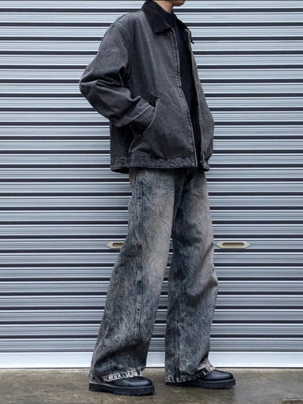 ブラック系のカバーオール、ブルー系のデニムパンツ、ブラック系のドレスシューズを着用したメンズの秋コーディネートの2枚目の写真