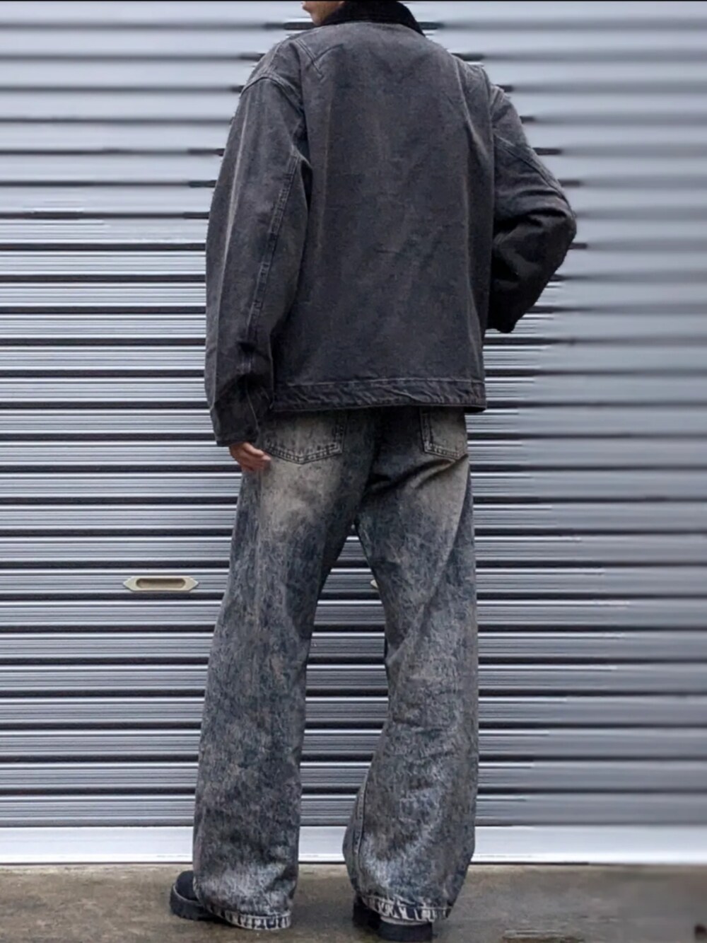 ブラック系のカバーオール、ブルー系のデニムパンツ、ブラック系のドレスシューズを着用したメンズの秋コーディネートの3枚目の写真