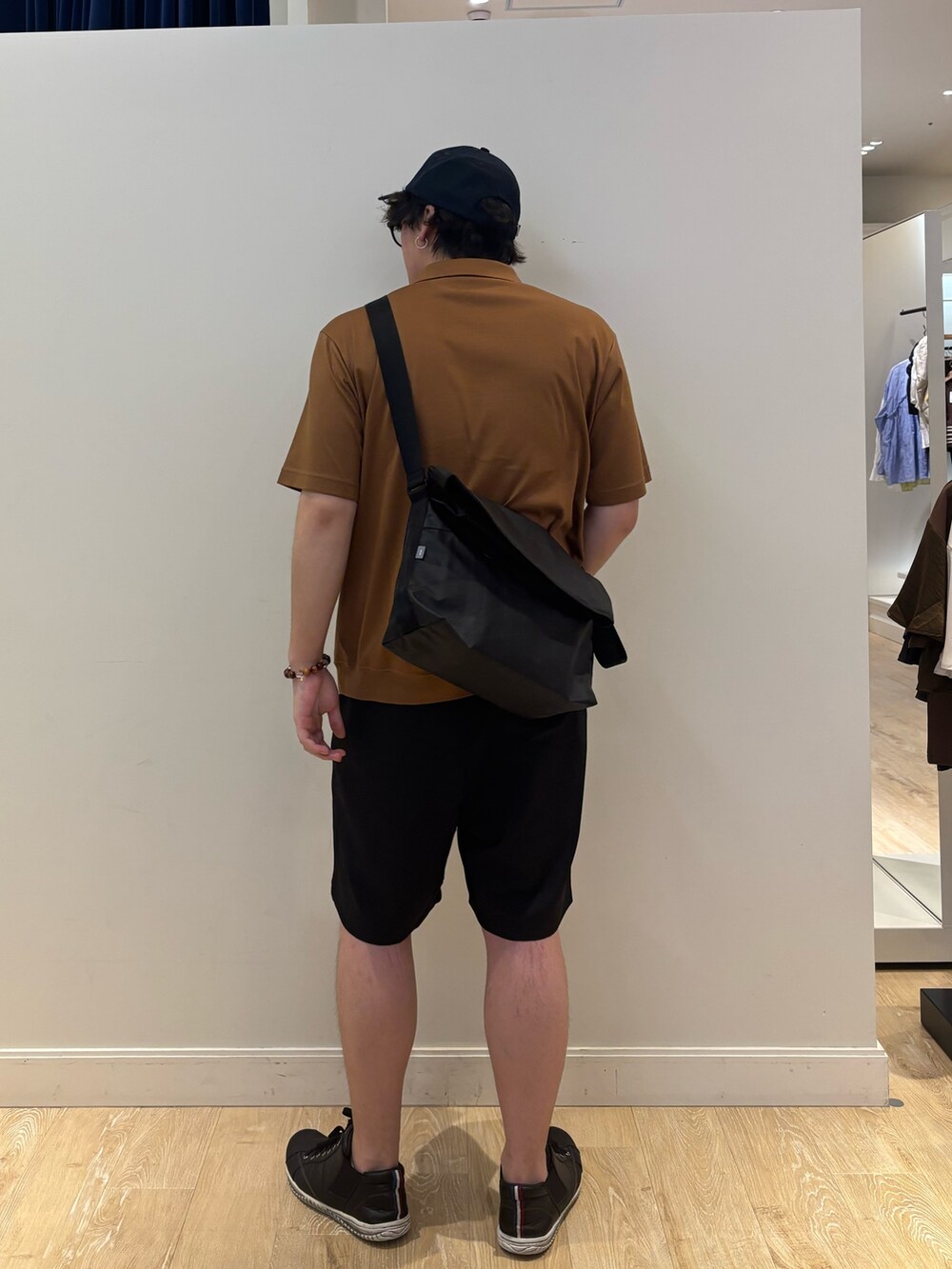 ブラック系のショルダーバッグ、イエロー系のポロシャツ、ブルー系のキャップを着用したメンズの夏コーディネートの4枚目の写真