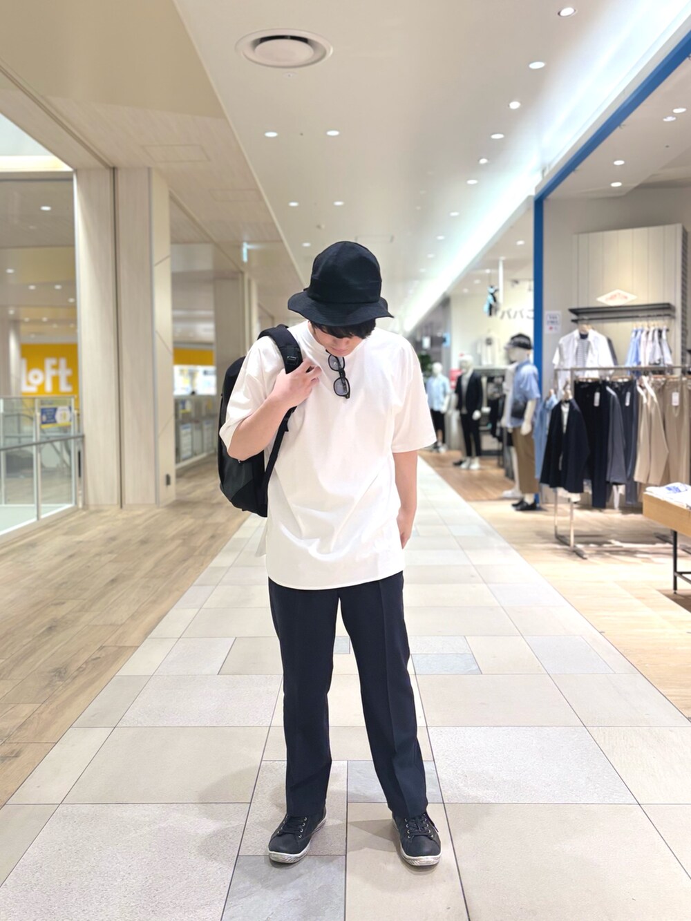 グレー系のその他パンツ、ブラック系のバックパック/リュック、ホワイト系のTシャツ/カットソーを着用したメンズの春コーディネートの4枚目の写真