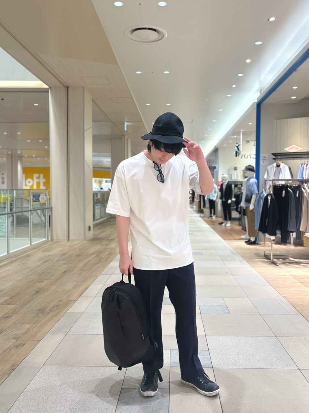 グレー系のその他パンツ、ブラック系のバックパック/リュック、ホワイト系のTシャツ/カットソーを着用したメンズの春コーディネートの2枚目の写真