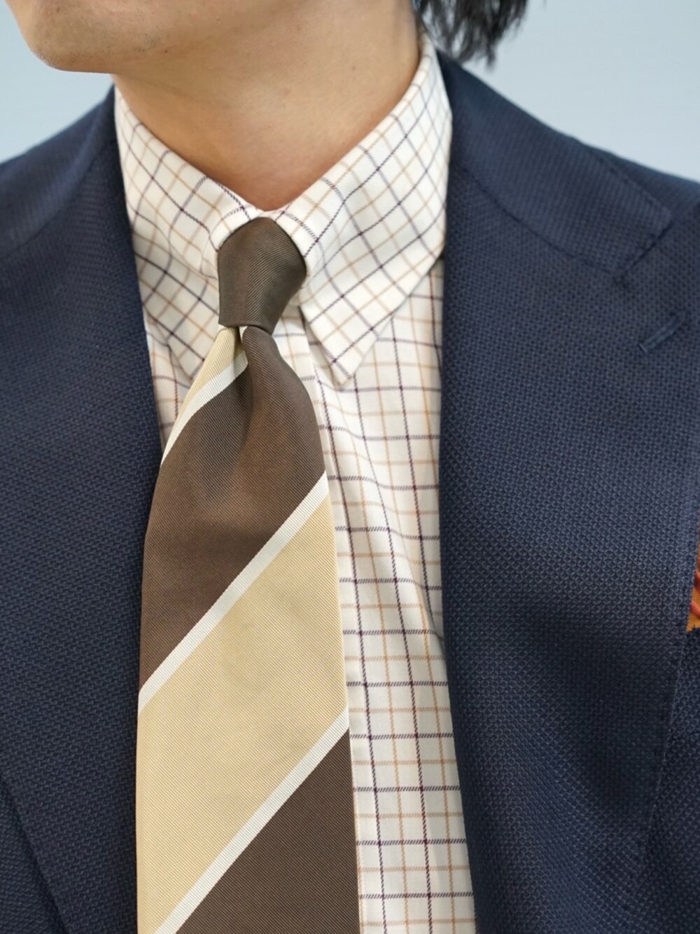 ブルー系のテーラードジャケット、ベージュ系のネクタイを着用したメンズの春コーディネートの3枚目の写真