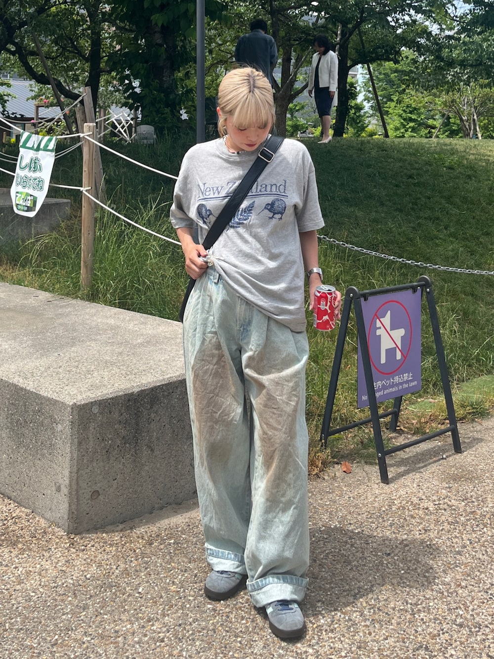 ブルー系のスニーカー、ブルー系のデニムパンツ、ブラック系のショルダーバッグを着用したレディースの春コーディネートの2枚目の写真