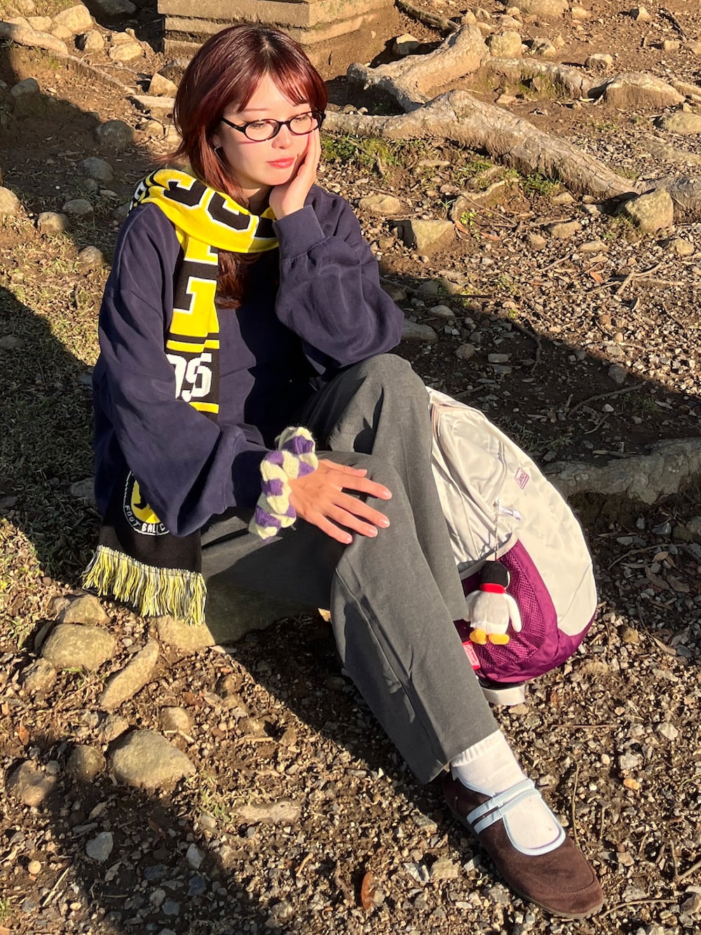 ブルー系のスウェット、グレー系のパンツ、ベージュ系のバックパック/リュックを着用したレディースの秋コーディネートの2枚目の写真