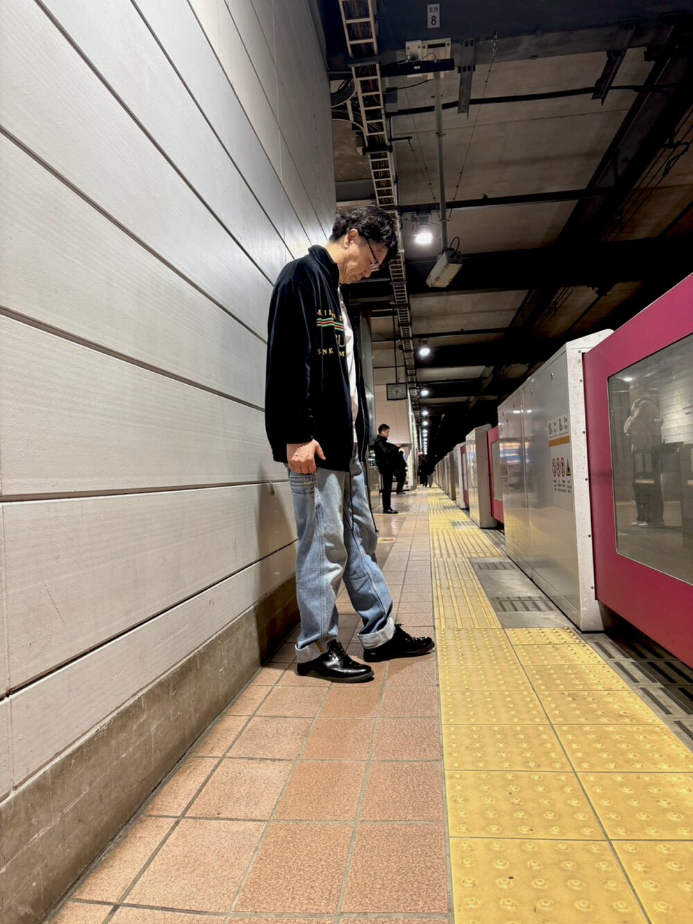 ブラック系のブルゾン、ブルー系のデニムパンツを着用したメンズの春コーディネートの2枚目の写真