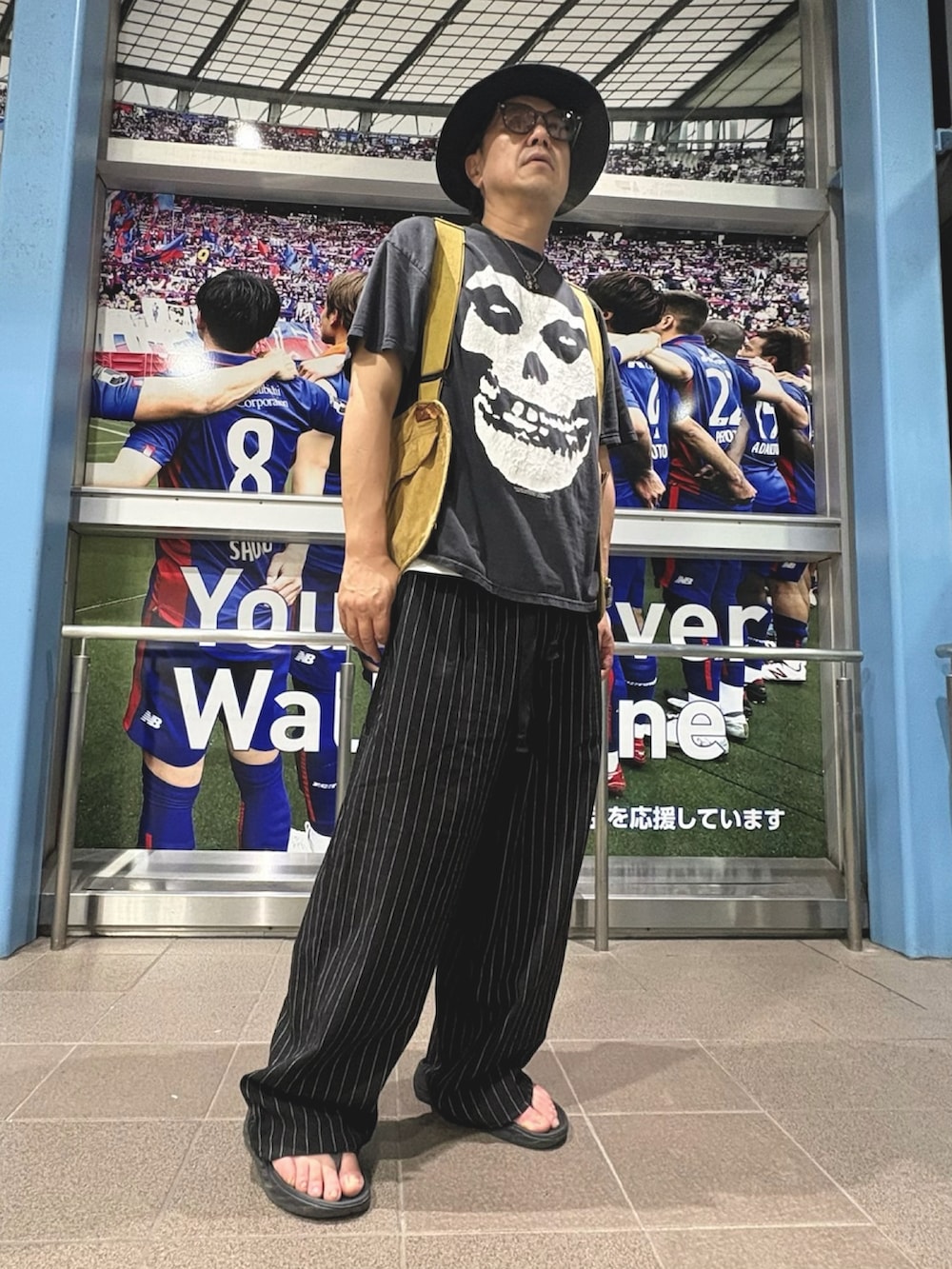 ブラック系のパンツ、イエロー系のベストを着用したメンズの夏コーディネートの3枚目の写真