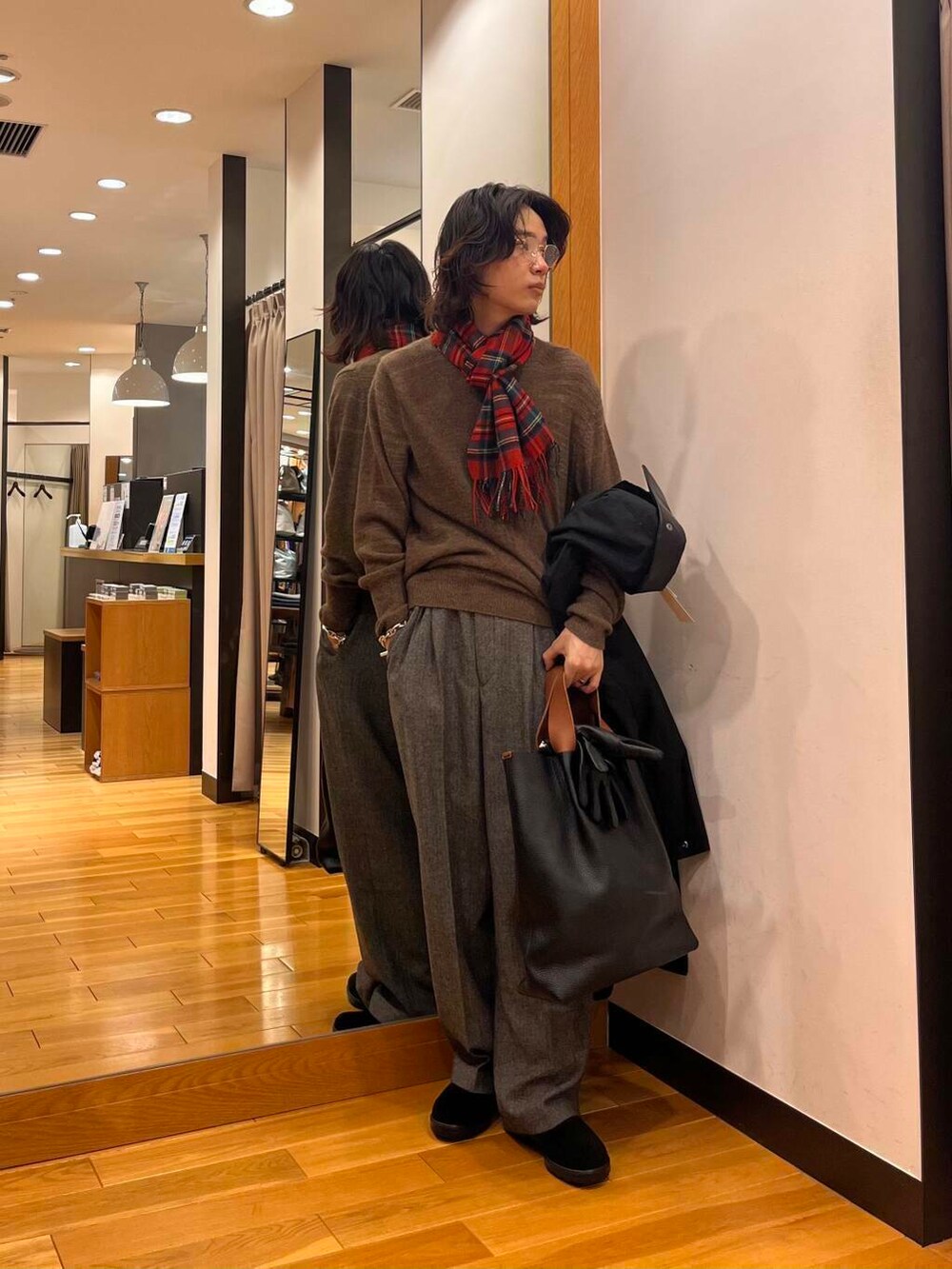 ブラック系のステンカラーコート、ブラック系のブーツ、グレー系のスラックスを着用したメンズの秋コーディネートの2枚目の写真