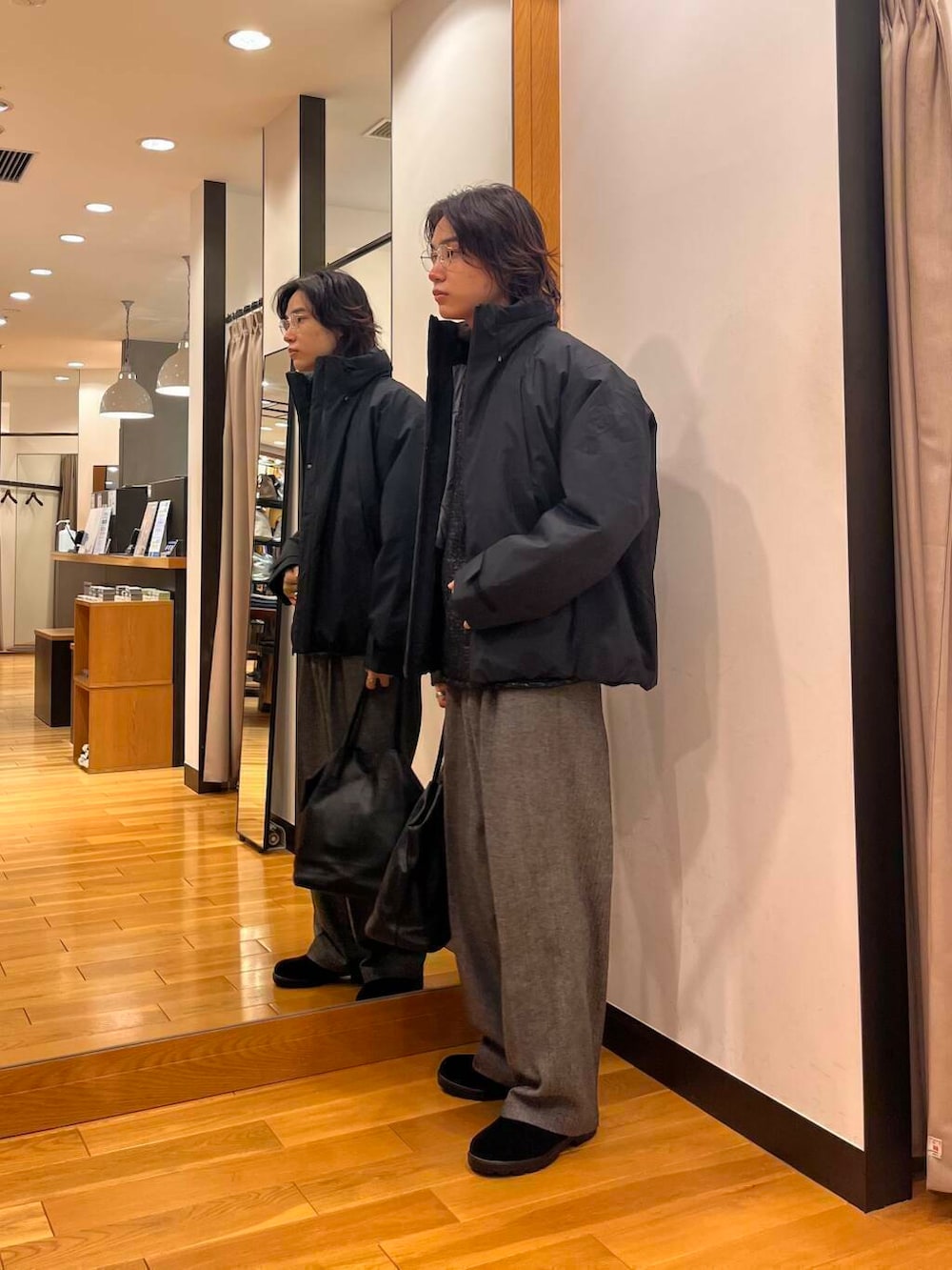 ブラック系のダウンジャケット/コート、ブラック系のニット/セーター、ブラック系のブーツを着用したメンズの秋コーディネートの2枚目の写真