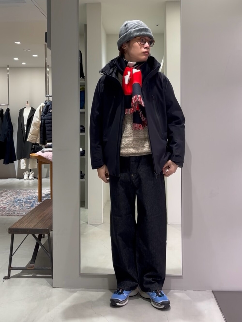 ブルー系のスニーカー、ベージュ系のニット/セーター、ブラック系のデニムパンツを着用したメンズの秋コーディネートの2枚目の写真