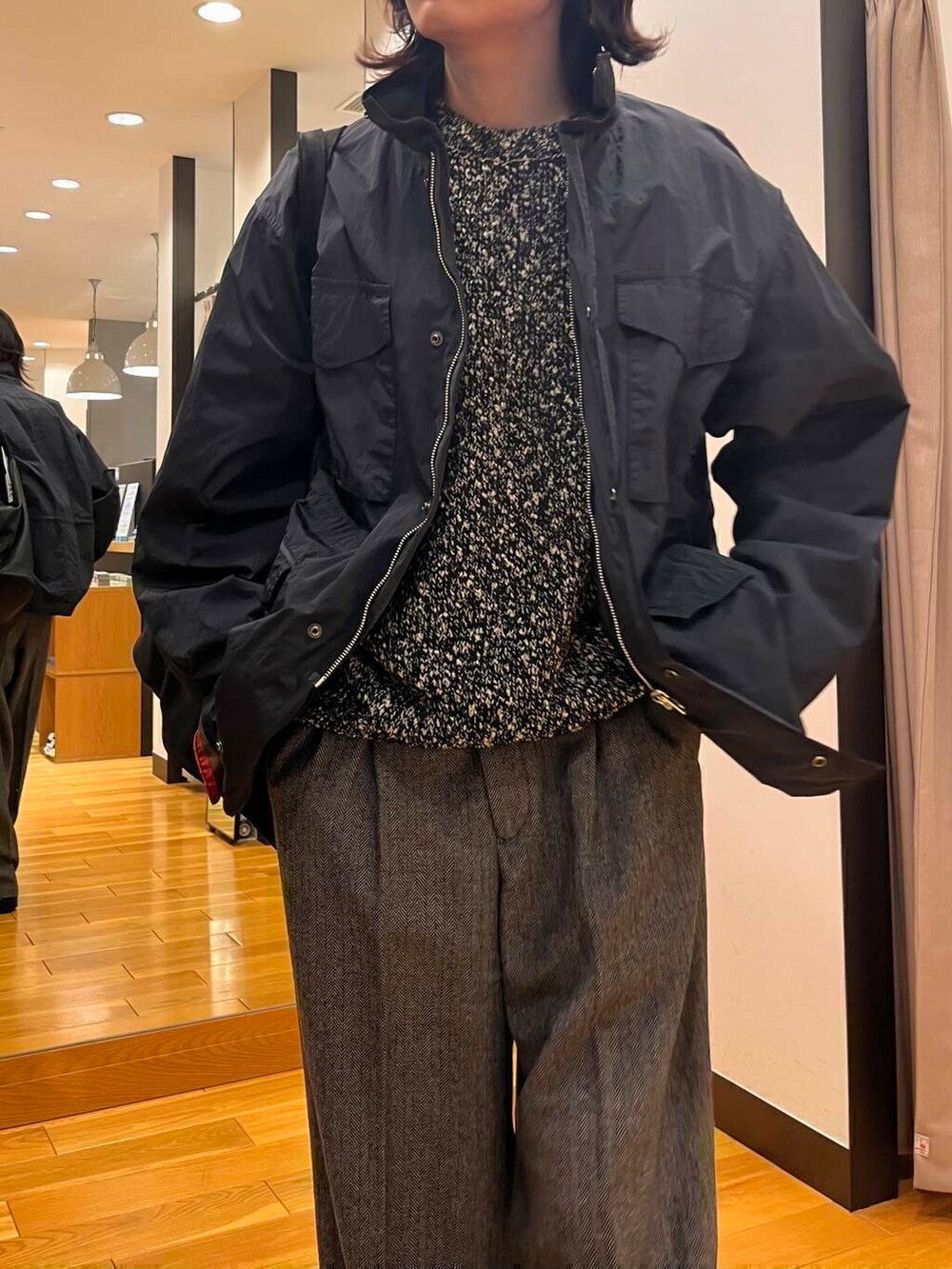 グレー系のナイロンジャケット、ブラック系のニット/セーター、ブラック系のブーツを着用したメンズの秋コーディネートの6枚目の写真