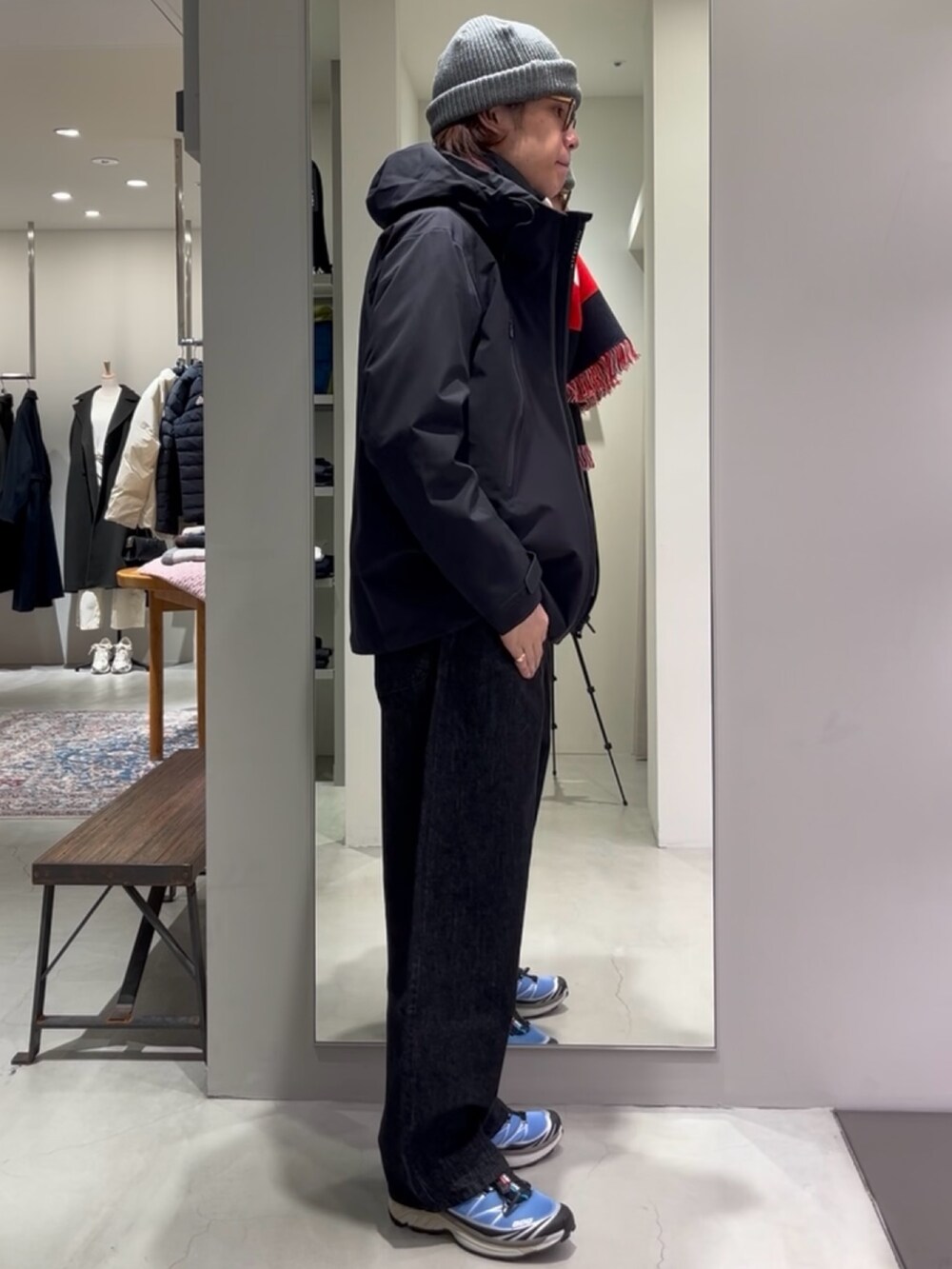 ブルー系のスニーカー、ベージュ系のニット/セーター、ブラック系のデニムパンツを着用したメンズの秋コーディネートの5枚目の写真