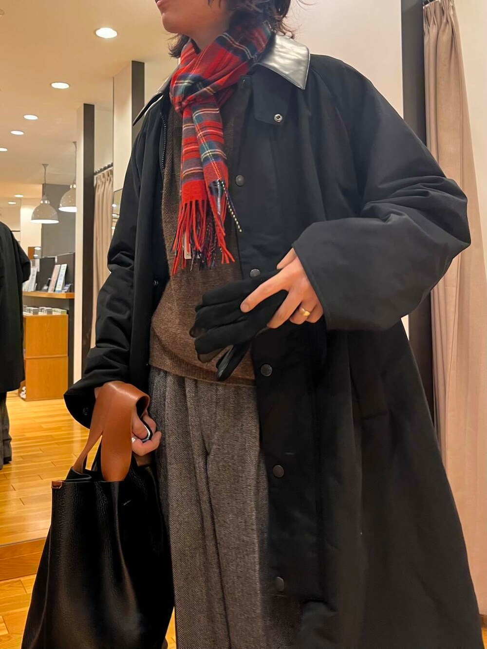 ブラック系のステンカラーコート、ブラック系のブーツ、グレー系のスラックスを着用したメンズの秋コーディネートの5枚目の写真