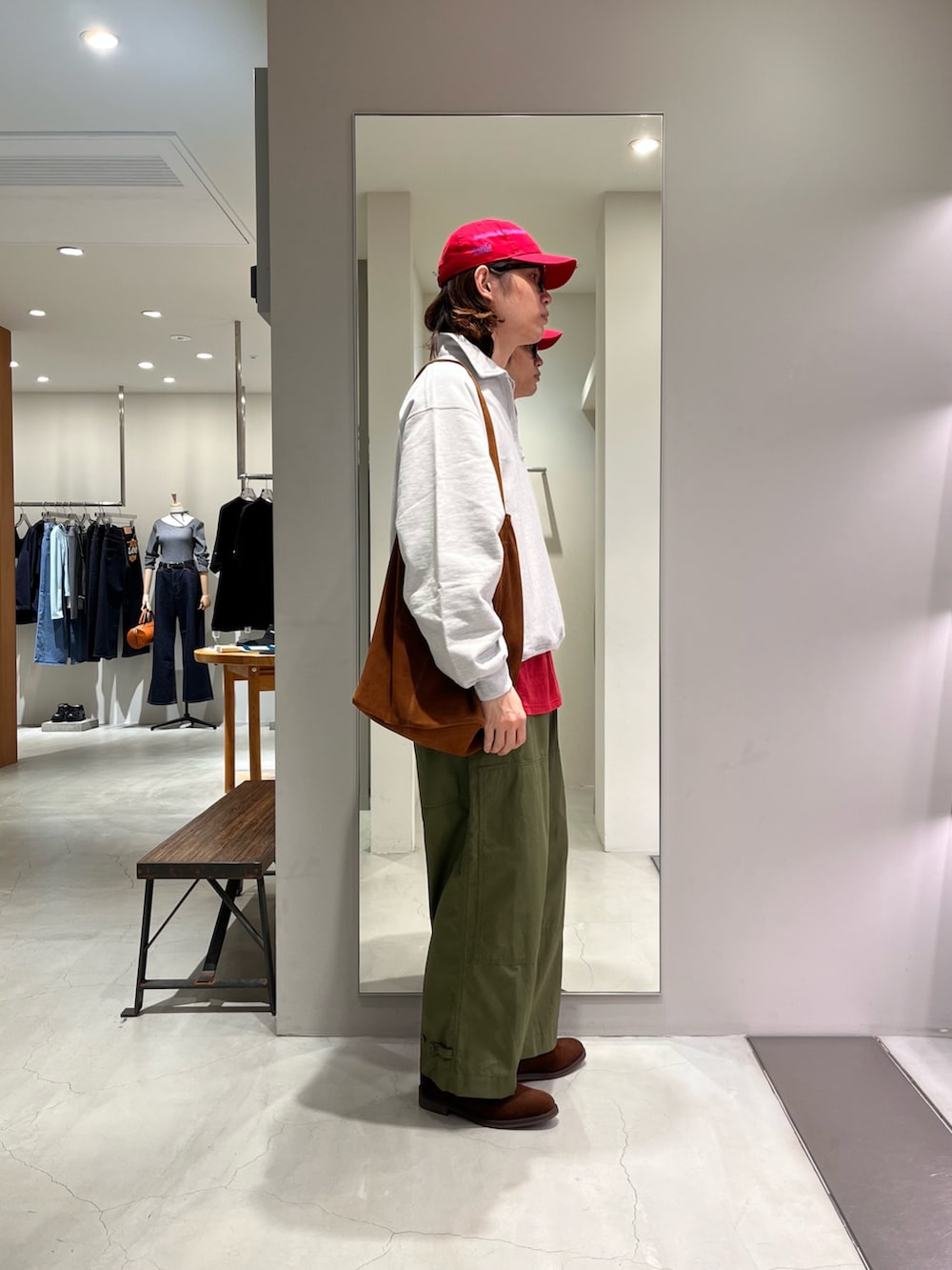 レッド系のTシャツ/カットソー、ブラウン系のトートバッグ、レッド系のキャップを着用したメンズの春コーディネートの2枚目の写真